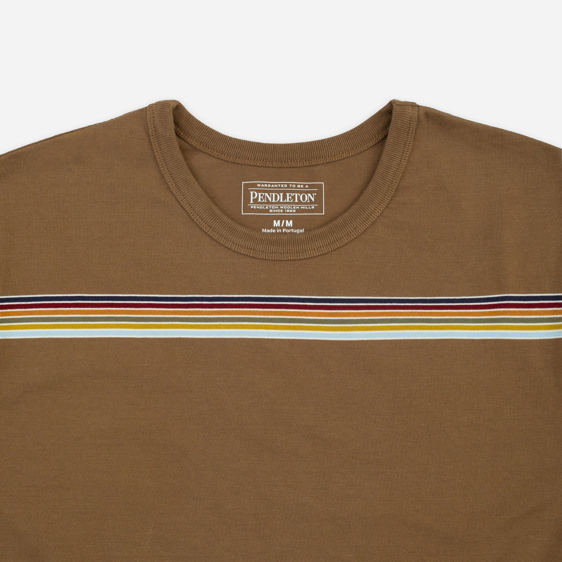A close-up of a Pendleton brown crewneck t-shirt featuring a horizontal stripe pattern across the chest in navy, red, yellow, and white.