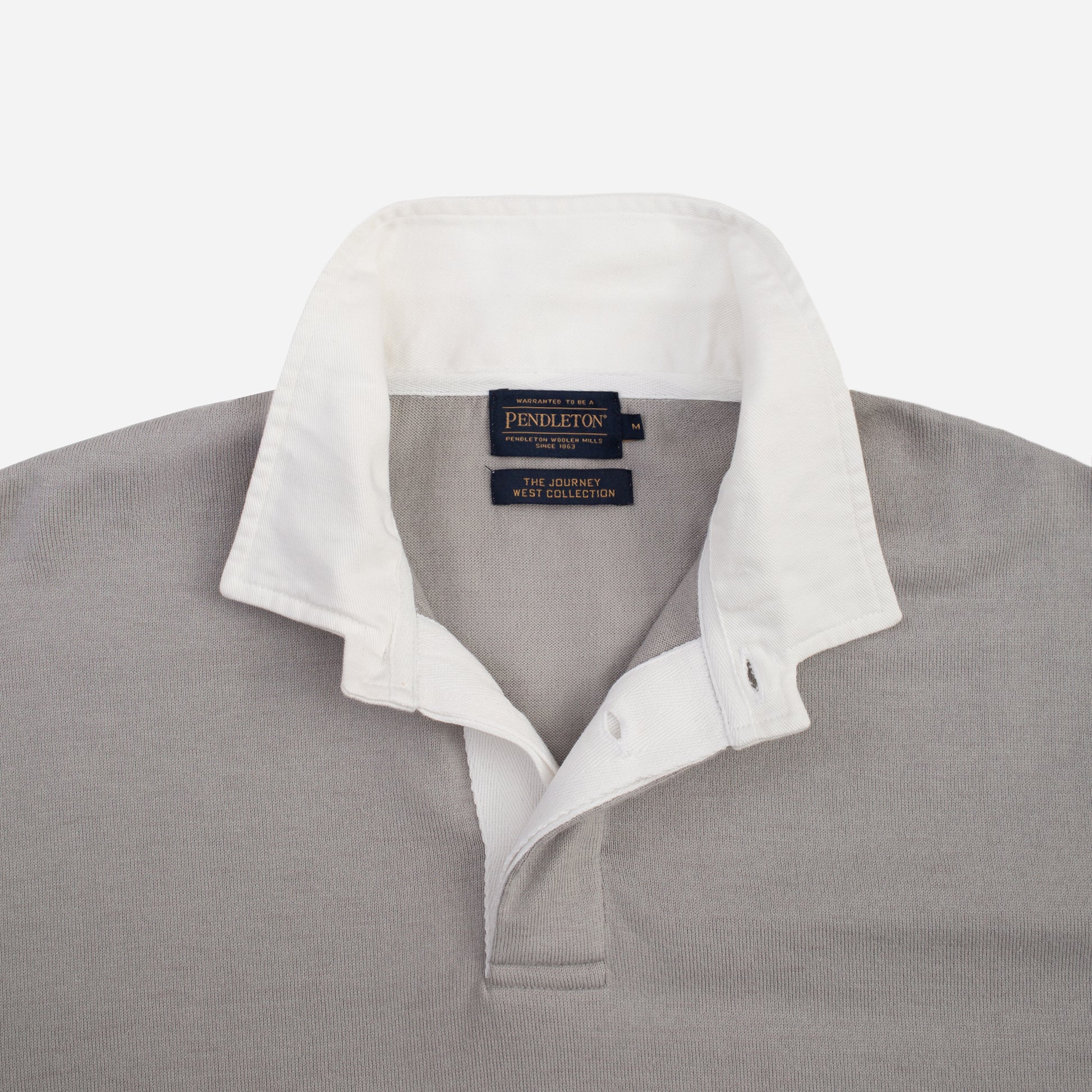 A close-up of a Pendleton wool sweater showing the collar and inner placket. The outer fabric is a textured light gray, while the inner collar and placket lining are white.