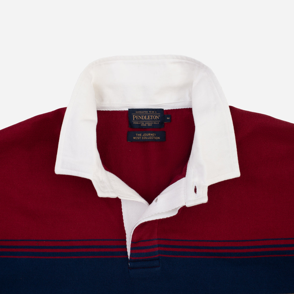 A close-up of a Pendleton wool sweater collar showing the brand label and the color blocking of deep red, white, and navy blue.